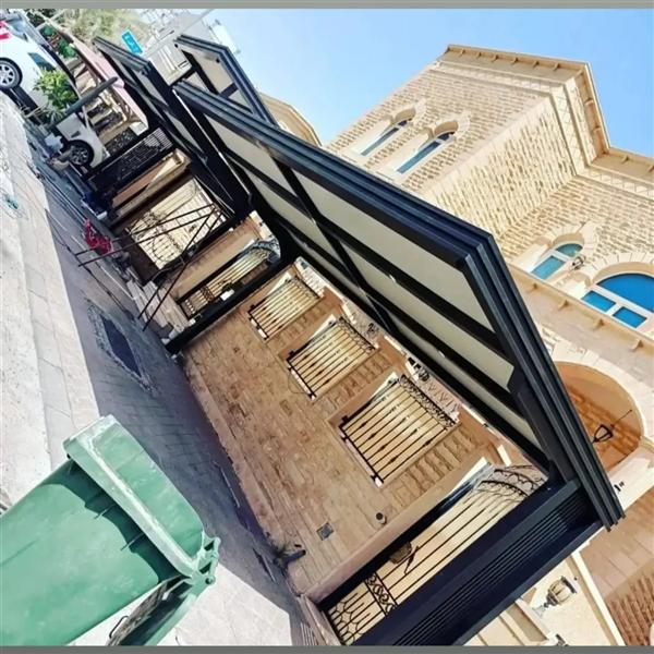 مظلة سيارات سوداء على امتداد واجهة منزل